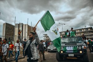 Grupo de pessoas caminhando na rua segurando bandeira na África