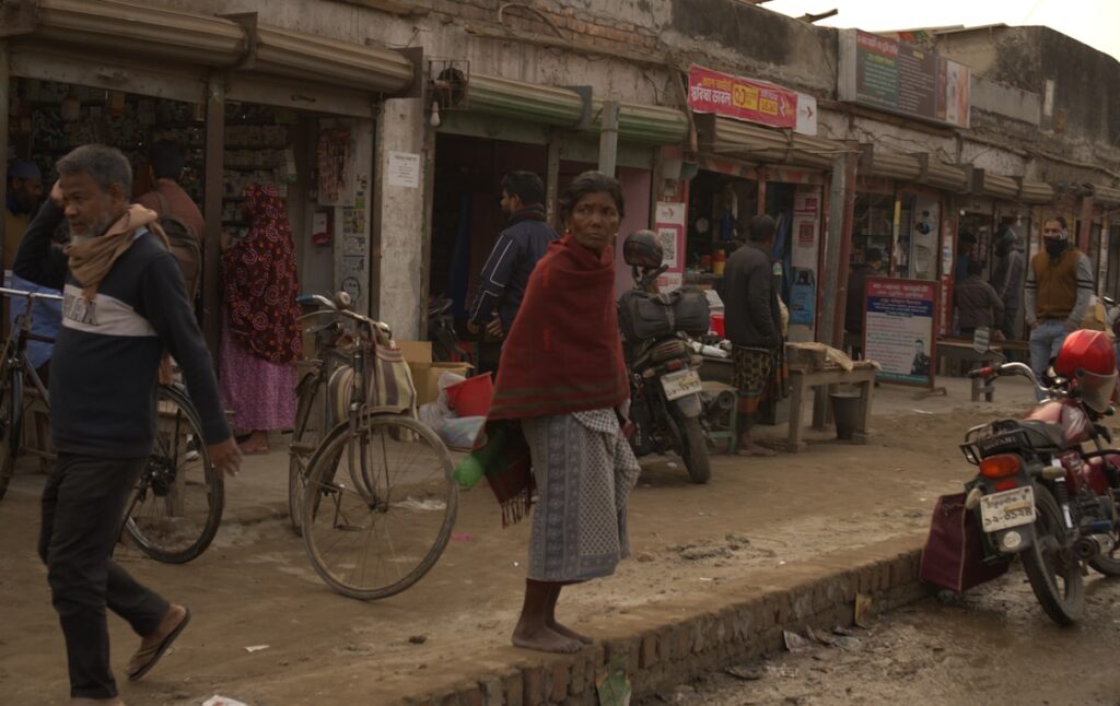 Rua movimentada com lojas e motocicletas em Bangladesh